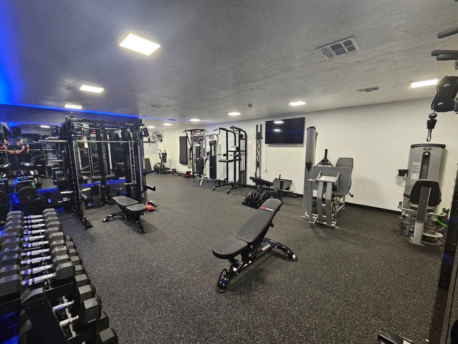 Detail of organized dumbbells and kettlebells at On Point Fitness.